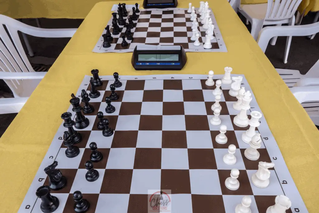 A picture of tournament chess boards set up in a chess club with digital chess clocks in place to control the time